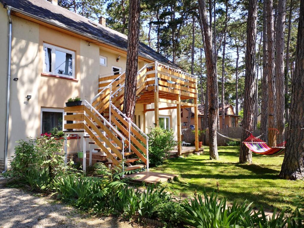una casa con una escalera de madera en el patio en House Italy, en Siófok
