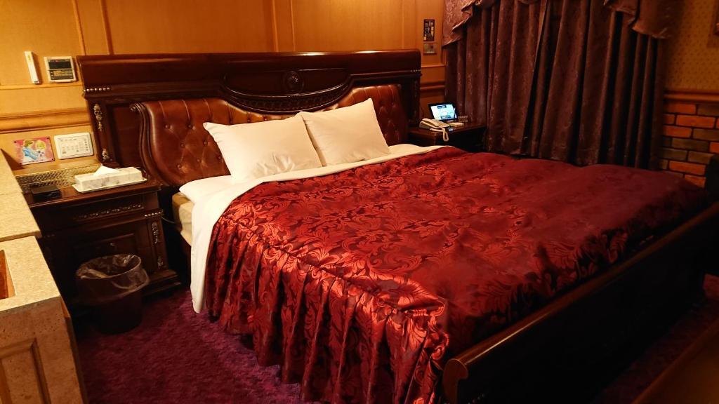a bedroom with a large bed with a red blanket at Hotel Zips (Adult Only) in Kawaguchi