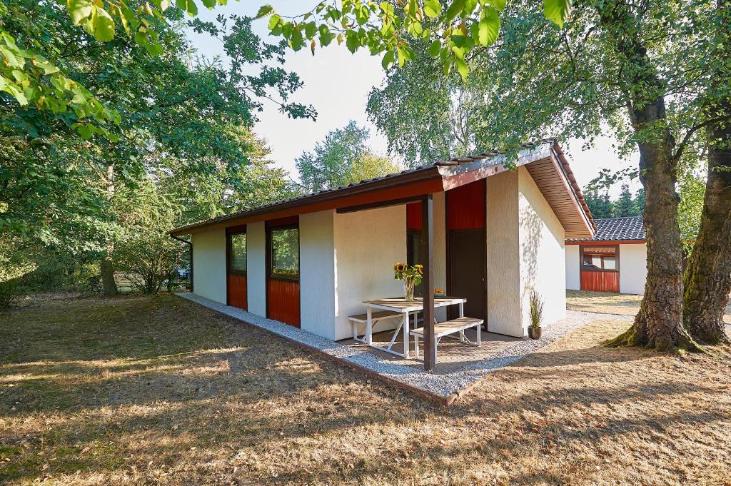 ein kleines Haus mit einem Picknicktisch im Hof in der Unterkunft Ferienpark Grafschaft Bentheim in Uelsen