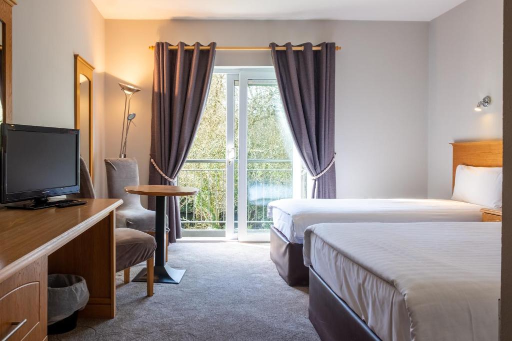 a bedroom with a bed and a television at The Lodge at Woodenbridge in Arklow