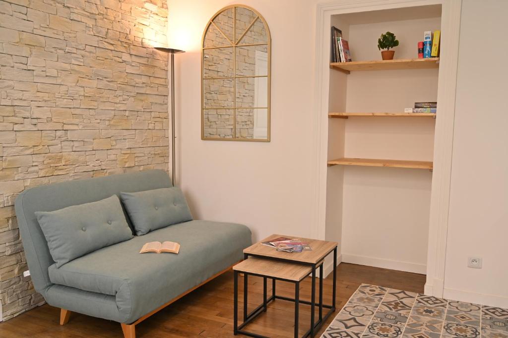 a living room with a couch and a table at Le Moutardier : chaleureux T2 au coeur de ville in Dijon