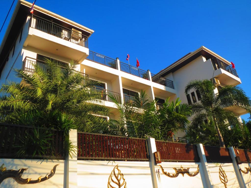 een gebouw met palmbomen ervoor bij Swiss Paradise Boutique Villa in Noord Pattaya
