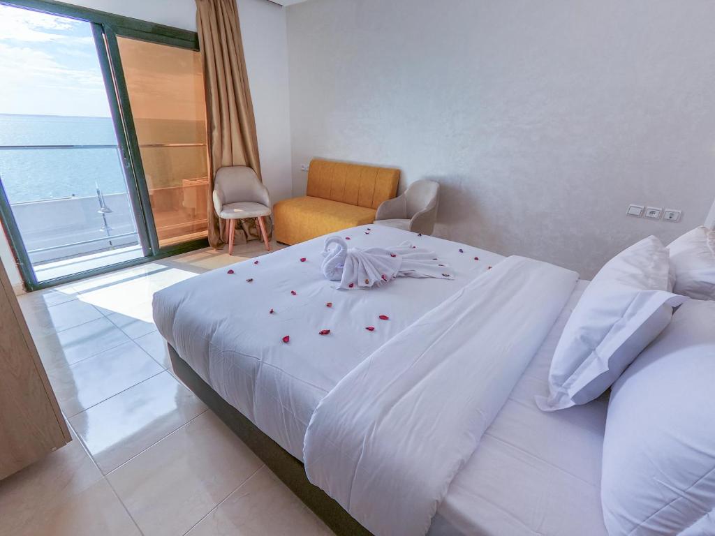 Un dormitorio con una gran cama blanca con rosas. en Marina Dreams en Dakhla