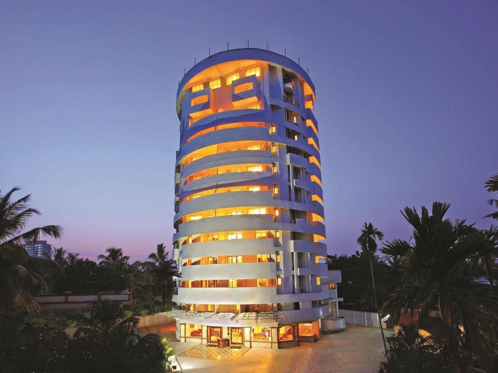 a tall building with lights on in front of it at Emarald Suites, Cochin in Cochin