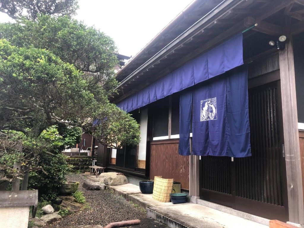 um edifício com uma bandeira azul ao lado em ゲストハウス Rei em Hongu