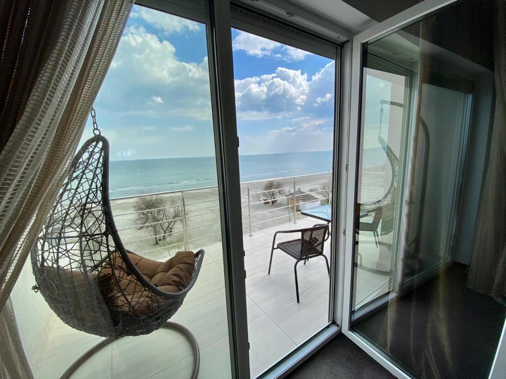 a hammock hanging from a window with a view of the ocean at Ella by the sea Residence in Mamaia Nord