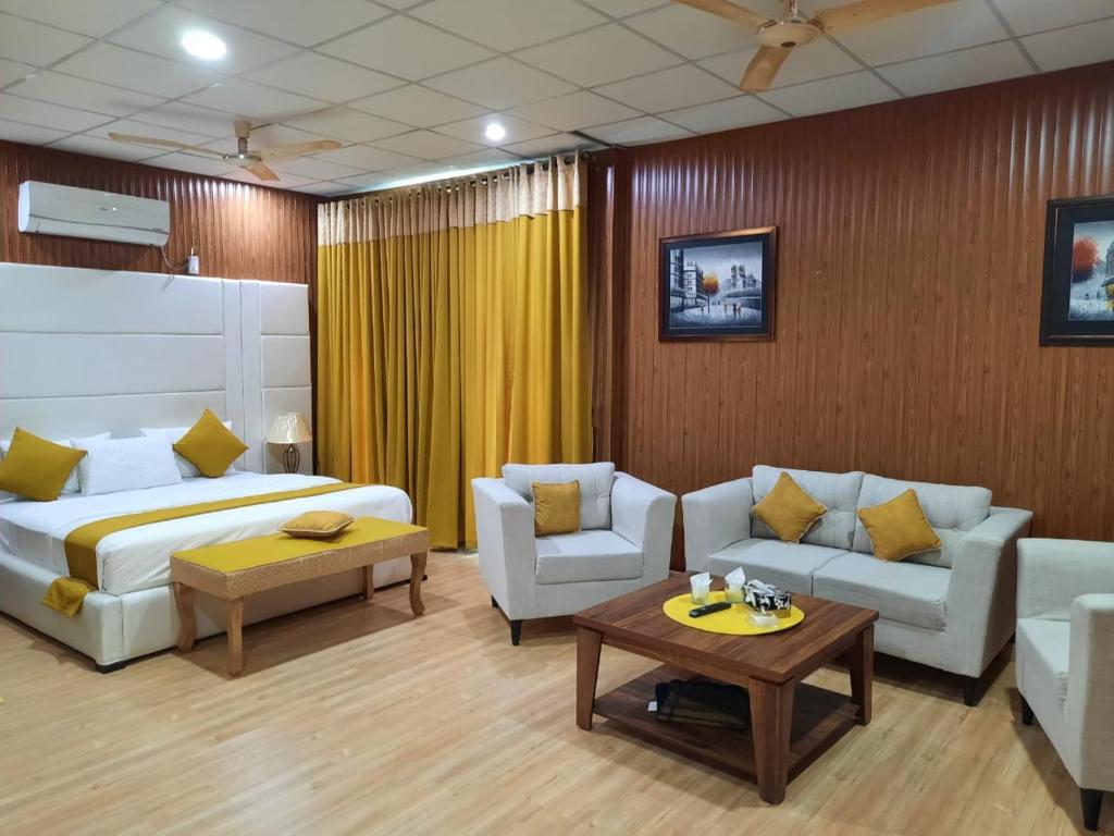 a hotel room with a bed and a couch and a table at Royal Motel Executive in Islamabad