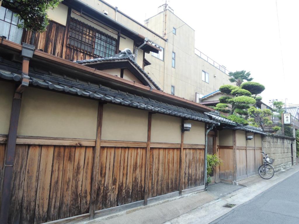 a building with a wooden fence next to a street at Tsubakiso in Nara