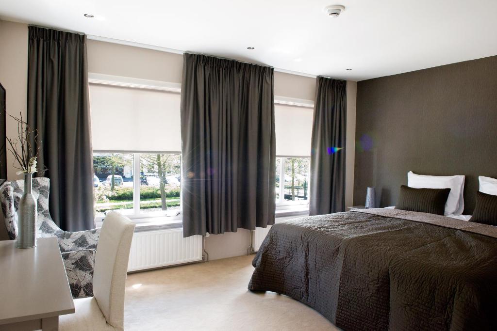 a bedroom with a bed and a large window at Hotel-Restaurant Thuis! in Dinteloord