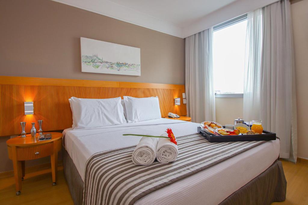 a hotel room with a large bed with two towels at Belo Horizonte Plaza in Belo Horizonte