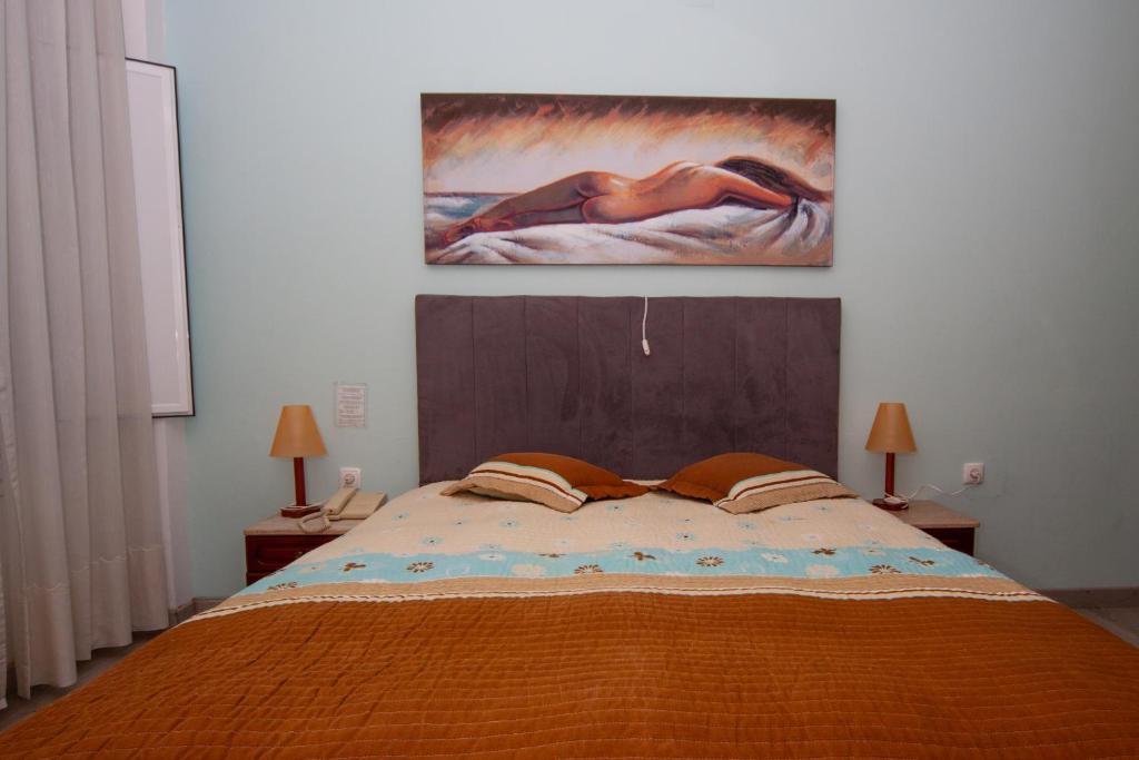 1 dormitorio con 1 cama con una pintura en la pared en Hotel Leiriense, en Leiria