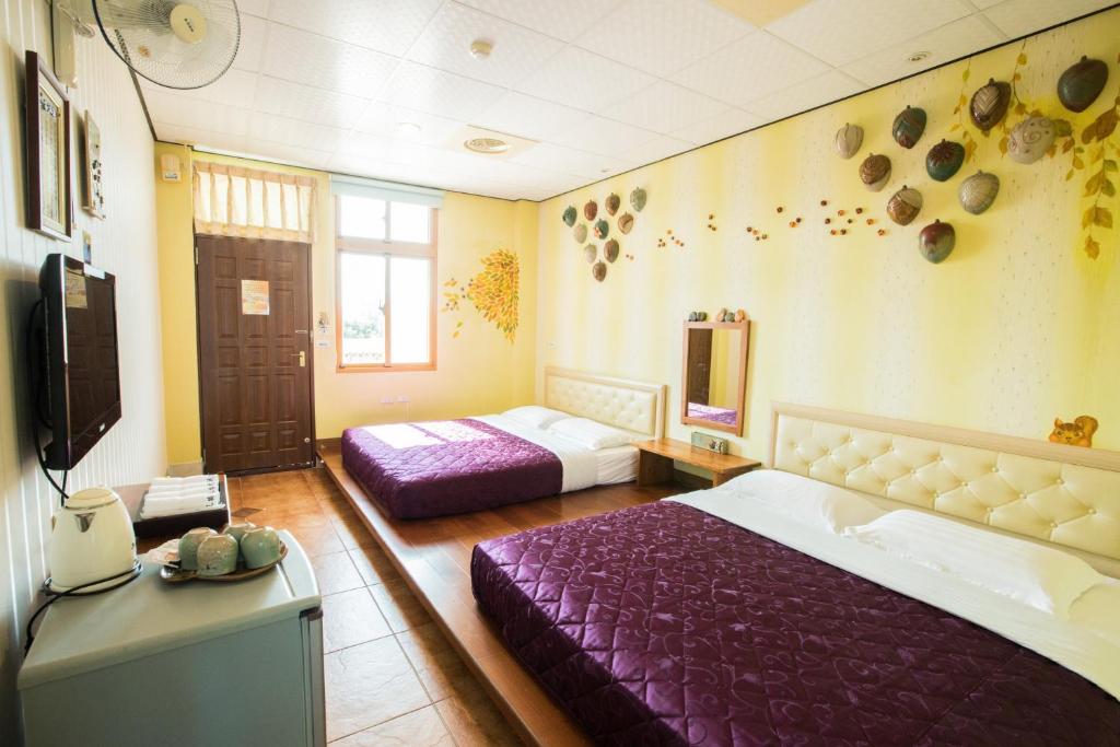 a bedroom with two beds and a tv in it at Family Pottery in Hengchun South Gate