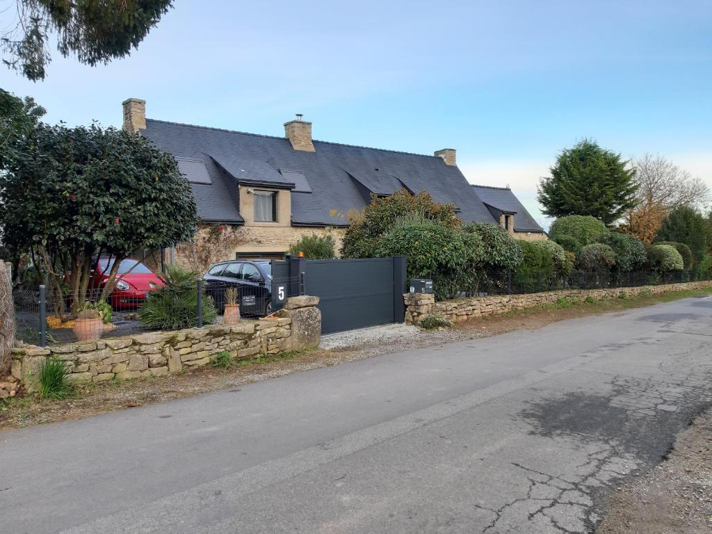 a house with a stone fence and a driveway at La Longère d'Arzoù, chambres d'hôtes in Baden