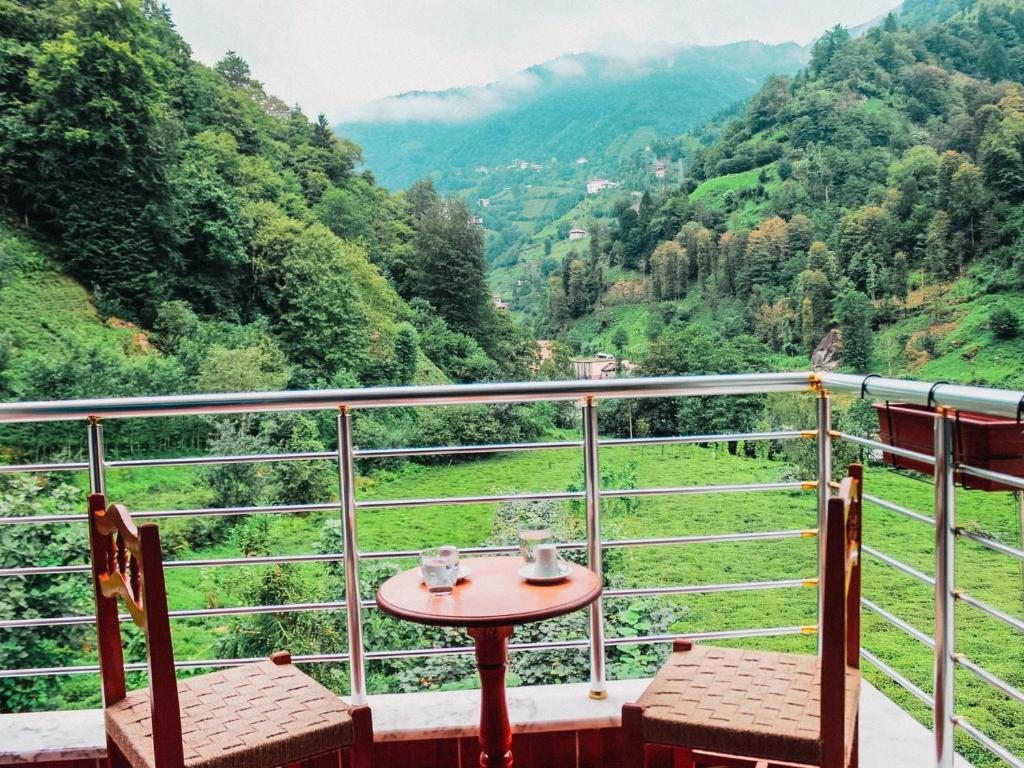 een tafel en stoelen op een balkon met uitzicht op een vallei bij Efulim Apart in Çamlıhemşin