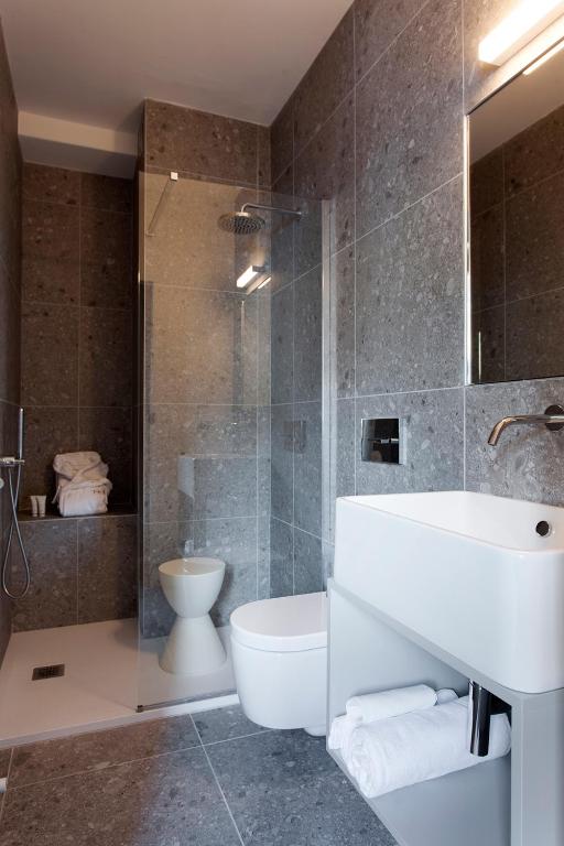 a bathroom with a sink and a toilet and a shower at Hotel Tremoggia in Chiesa in Valmalenco