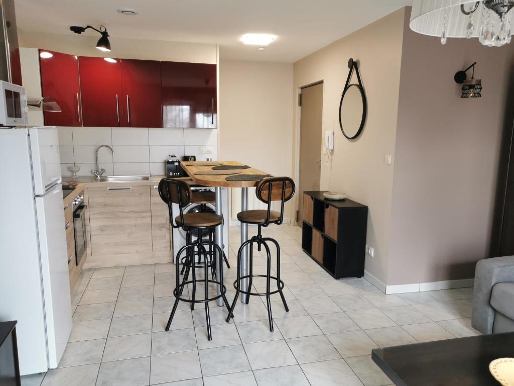 a kitchen with a table and some bar stools at Normandie, mer et campagne in Ver-sur-Mer