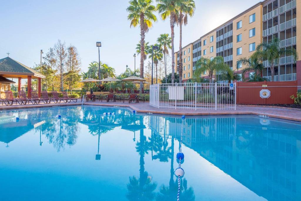 een groot zwembad met palmbomen en een gebouw bij Bluegreen Vacations Orlando's Sunshine Resort in Orlando