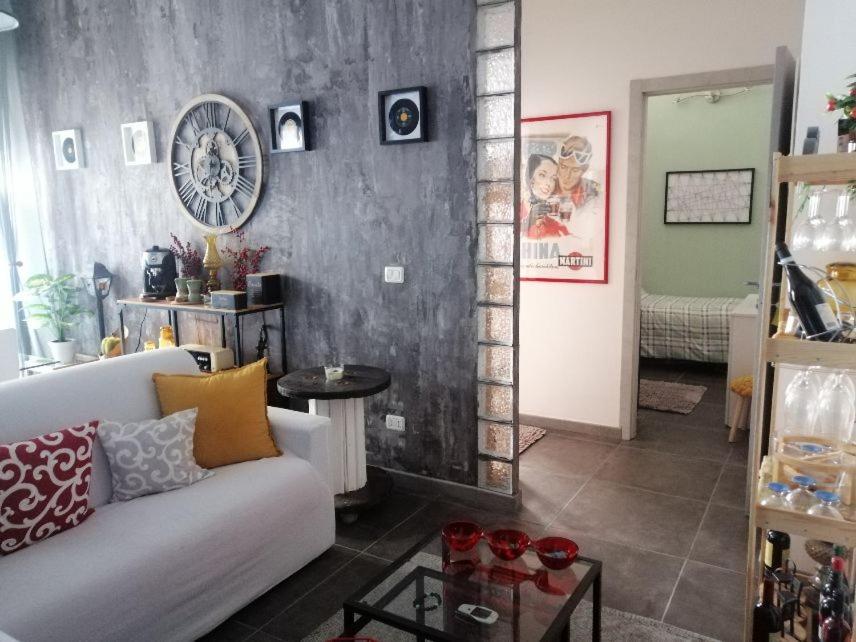 a living room with a white couch and a clock on the wall at suite del borgo in Turin