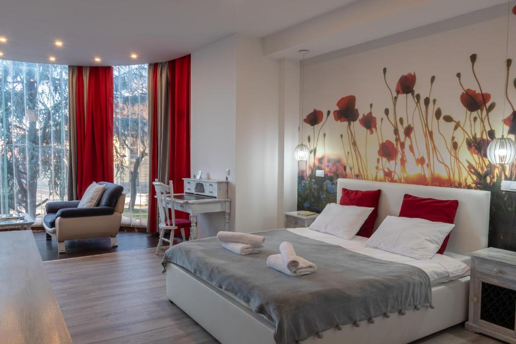 um quarto com uma cama grande com detalhes em vermelho em Green Town Apartments em Sombor