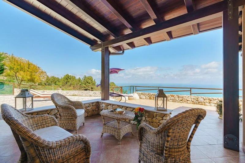 eine Terrasse mit Stühlen und einem Tisch mit Meerblick in der Unterkunft Villa dei Mori in Scopello