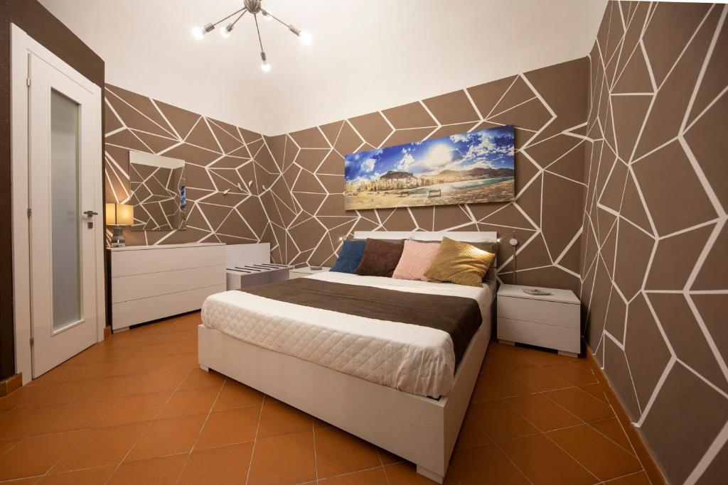 a bedroom with a bed and a tiled wall at Casa Ruggero in Cefalù