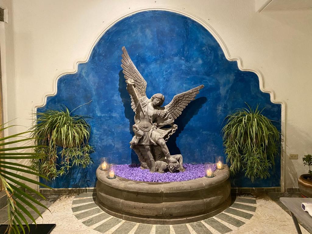 une statue d'un ange assis dans une fontaine dans l'établissement Casa Árbol Hotel, à San Miguel de Allende