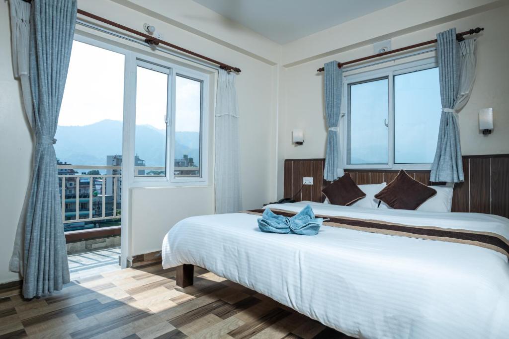 
a hotel room with a bed and a window at Pokhara Tourist Home in Pokhara

