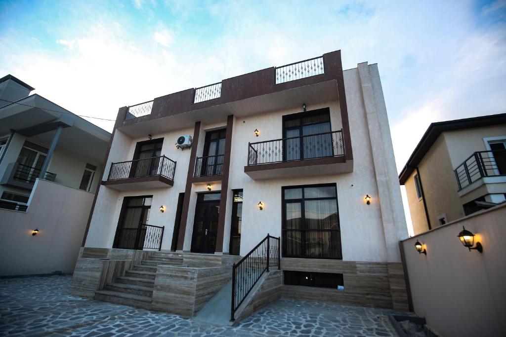 a large white building with stairs in front of it at Tbilisi Sea Hotel in Tbilisi City