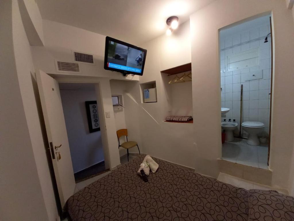 Hotel San Carlos في بوينس آيرس: غرفة فندقية بسرير وتلفزيون بشاشة مسطحة