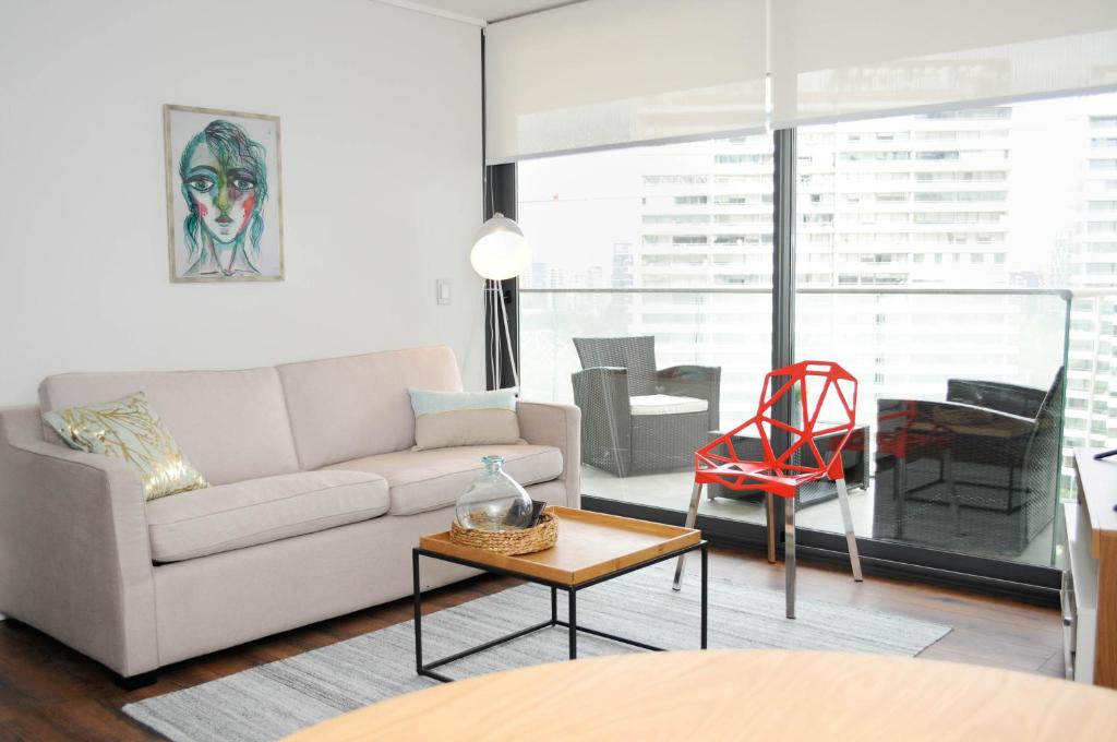 sala de estar con sofá y mesa en Apartment - Kennedy - Parque Arauco en Santiago