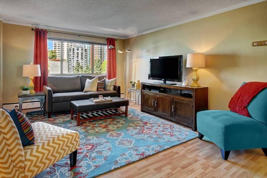a living room with a couch and a tv at Vibrant Downtown, King Bed, Work Desk & Kitchen in Seattle
