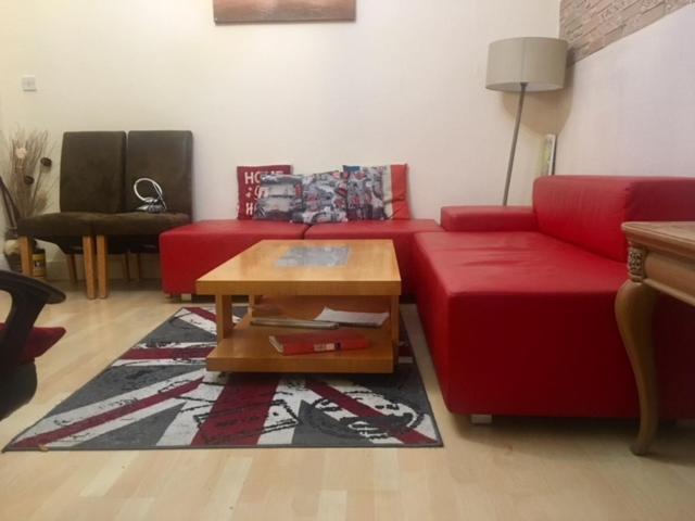 ロンドンにあるAffordable Home, London Eastのリビングルーム(赤いソファ、コーヒーテーブル付)