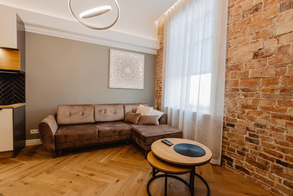 a living room with a couch and a brick wall at Võru Studio Apartment in Võru