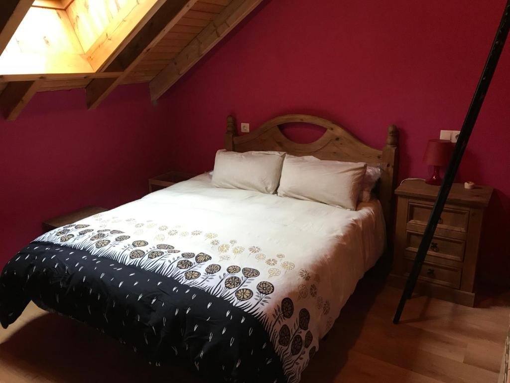 a bedroom with a large bed with a wooden headboard at Alojamientos Casa San Habitaciónes in Besande