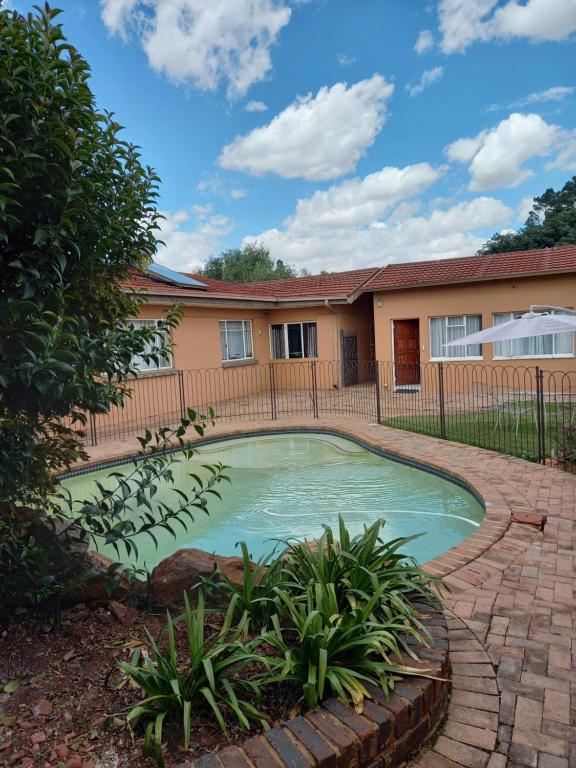 uma piscina no quintal de uma casa em Amberlight Self Catering Accommodation em Krugersdorp