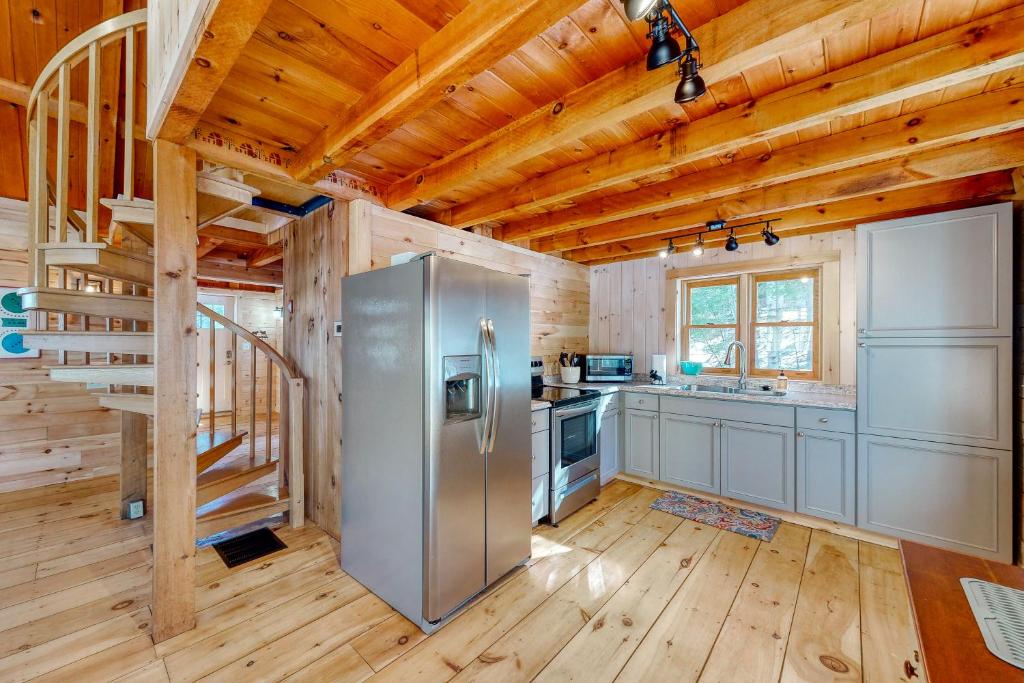 a kitchen with a stainless steel refrigerator and wooden walls at Camp Foxtrot in Greenville