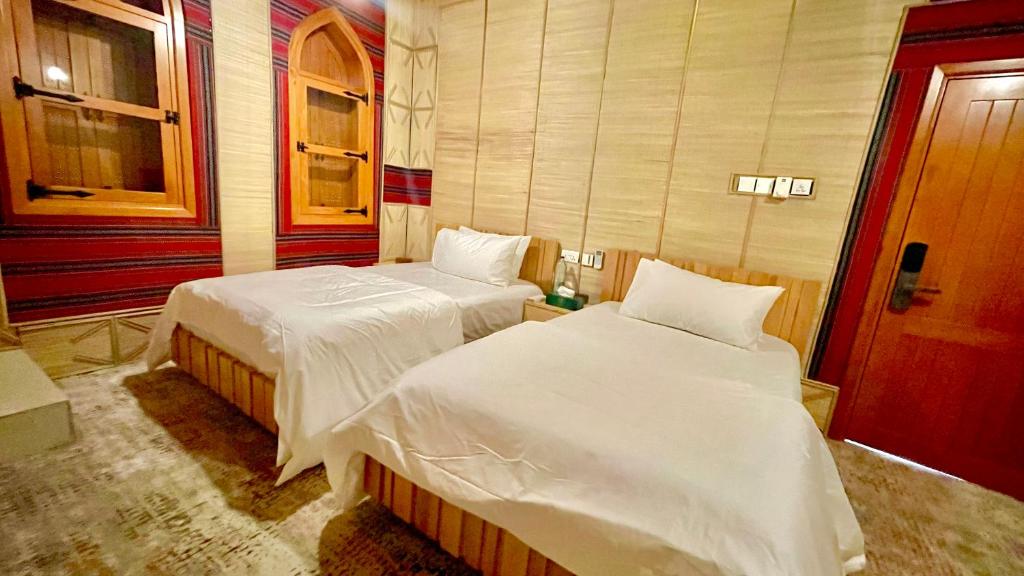 Postel nebo postele na pokoji v ubytování Fort Guesthouse نُزل القلعة