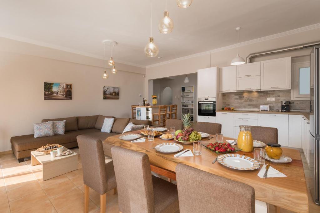 een keuken en een woonkamer met een houten tafel en stoelen bij UniQApt in Corfu-stad