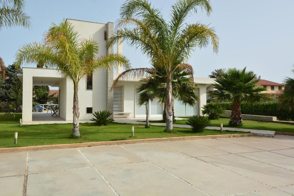 ein Haus mit Palmen davor in der Unterkunft Villa del Gelsomino in Punta Secca
