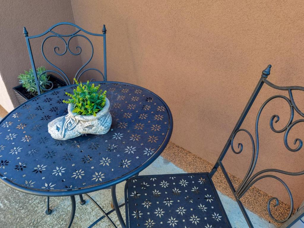 ein blauer Tisch mit einer Topfpflanze darauf in der Unterkunft Apartman i studio apartman Vitana in Garešnica
