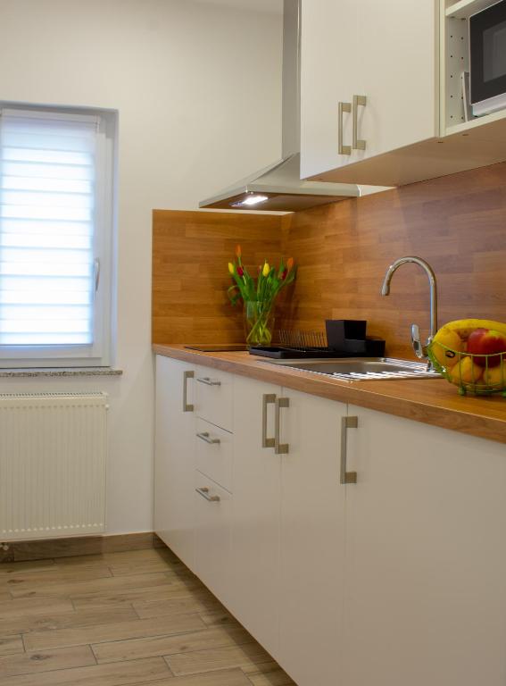 eine Küche mit weißen Schränken und einem Waschbecken in der Unterkunft Apartman i studio apartman Vitana in Garešnica