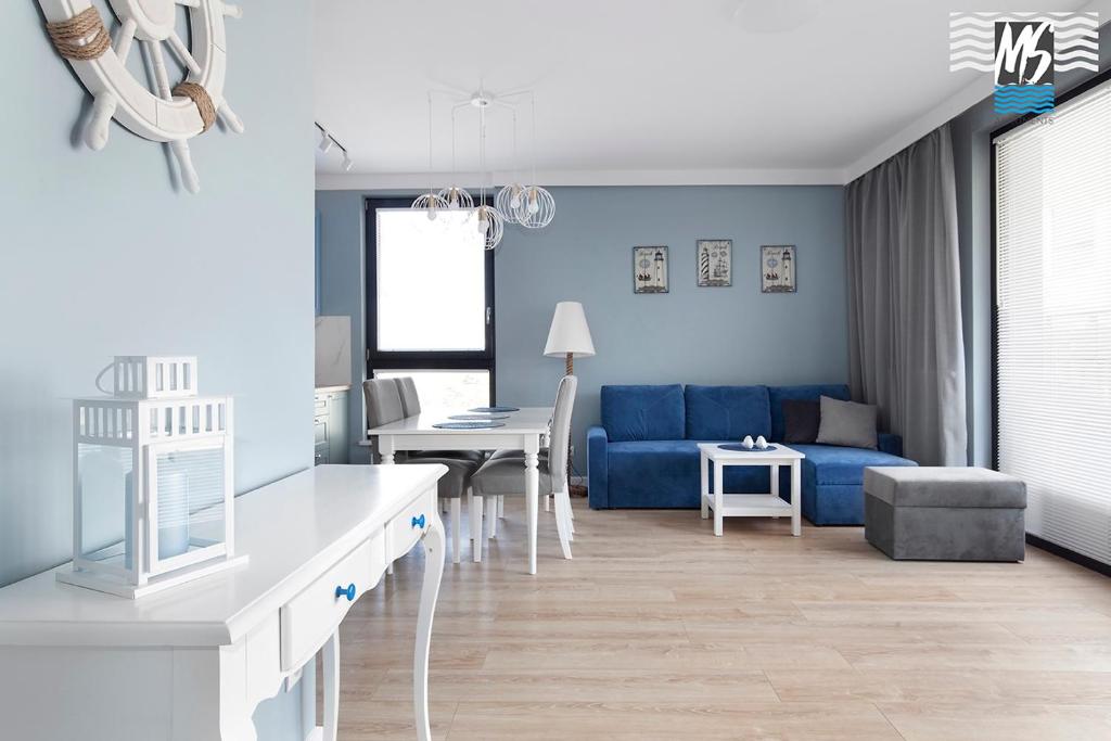 ein Wohnzimmer mit einem blauen Sofa und einem Tisch in der Unterkunft MS Apartments Matros in Gdynia