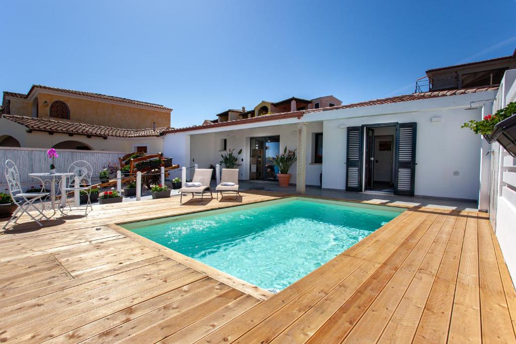 uma casa com uma piscina e um deque de madeira em Villa Elisir Luxury - Le Residenze del Mare em Porto San Paolo