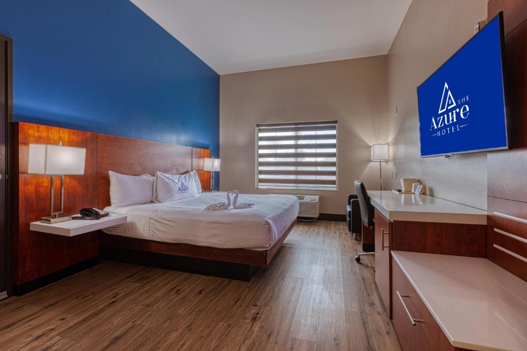 Habitación de hotel con cama y pared azul en The Azure Hotel, en Mesa