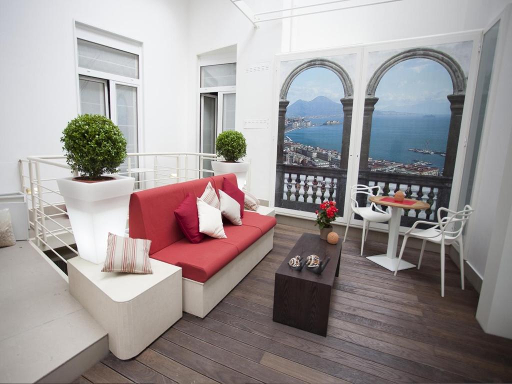 un soggiorno con divano rosso e tavolo di Napolart a Napoli
