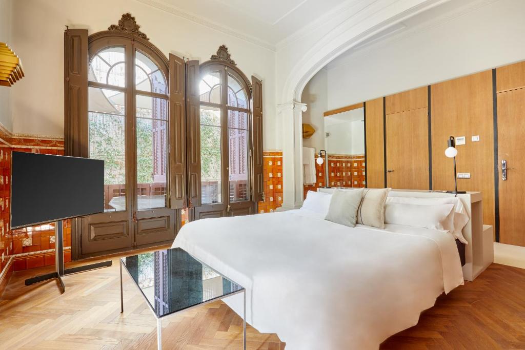 a hotel room with a large bed and a television at Sonder Le Palacete in Barcelona