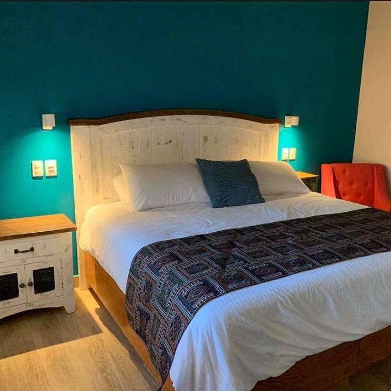 a bedroom with a large bed with a blue wall at Hotel Andares de Kino by Rotamundos in Magdalena de Kino