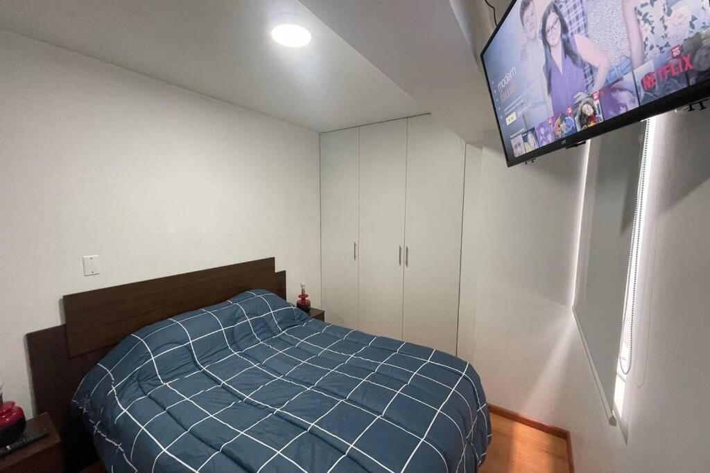 a bedroom with a bed and a flat screen tv at 6 - Departamento de 2 dormitorios en area turistica de Miraflores in Lima