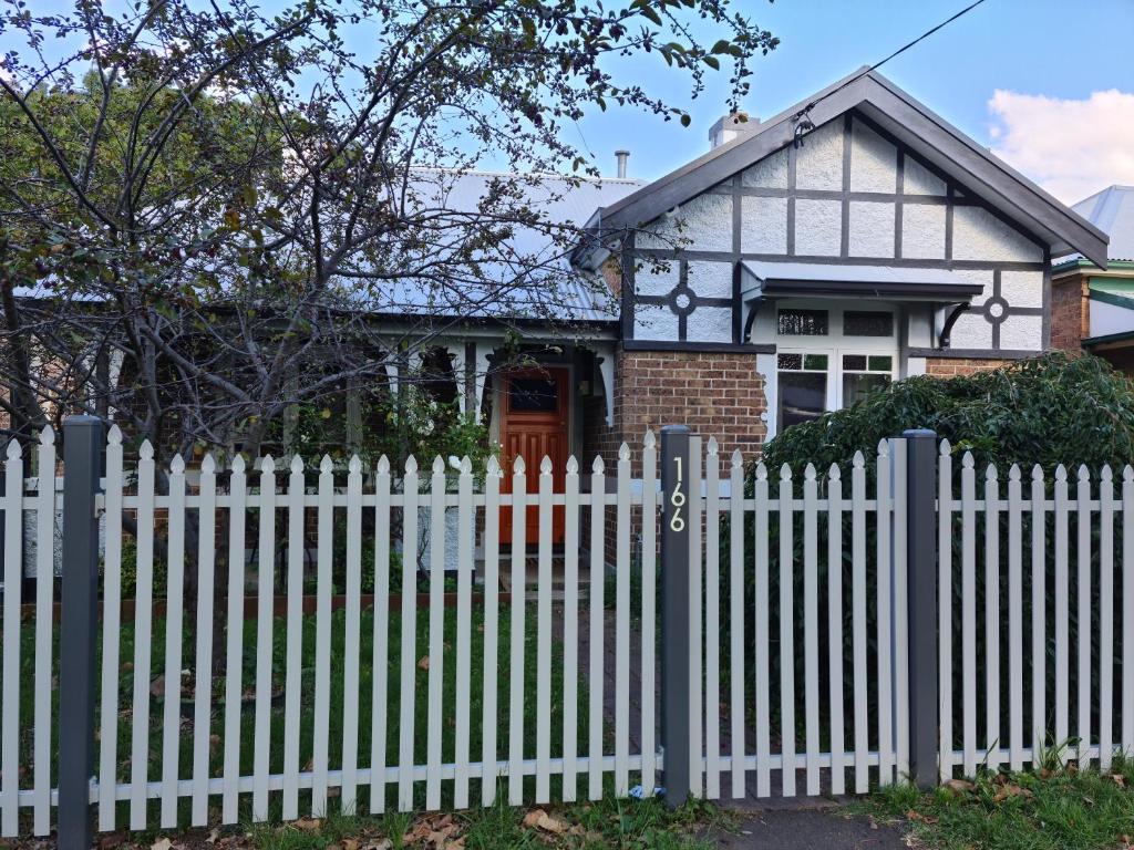 a white picket fence in front of a house at Arden on McLachlan in Orange