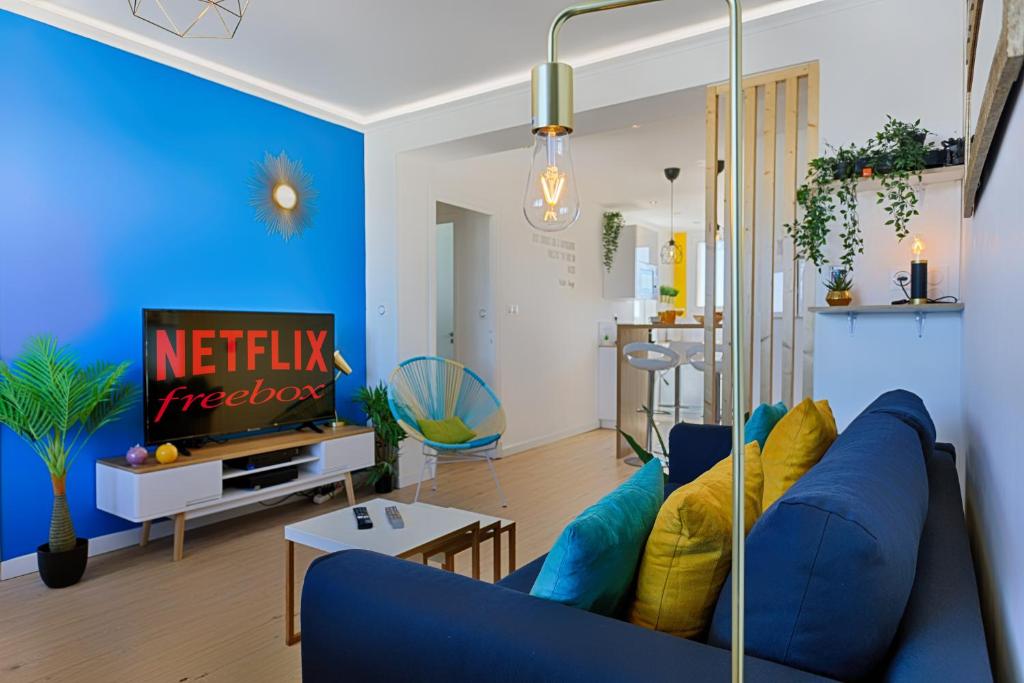 un salon avec un canapé bleu et une table dans l'établissement SMILE HÔME-Nid Panoramique VUE WOW ! SPAdéco - LoungeZEN - Terrasse ensoleillée - arrivée autonome - Netflix - emplacement idéal - Lumineux - rénové à neuf - Wifi Fibre -, à Montpellier